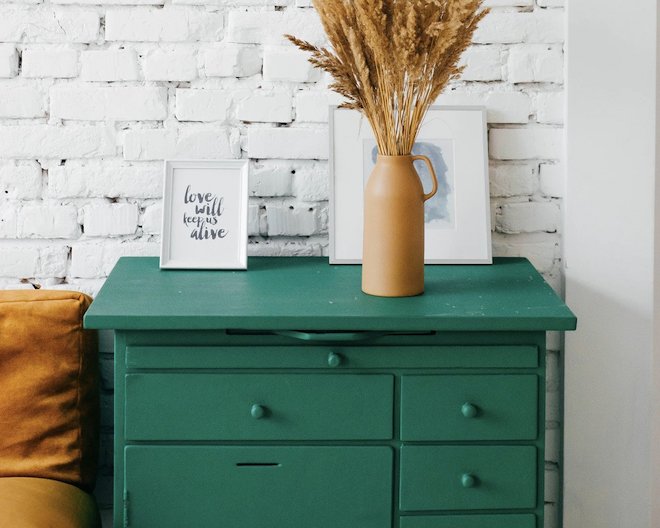 A green drawer with pictures and flowers on top